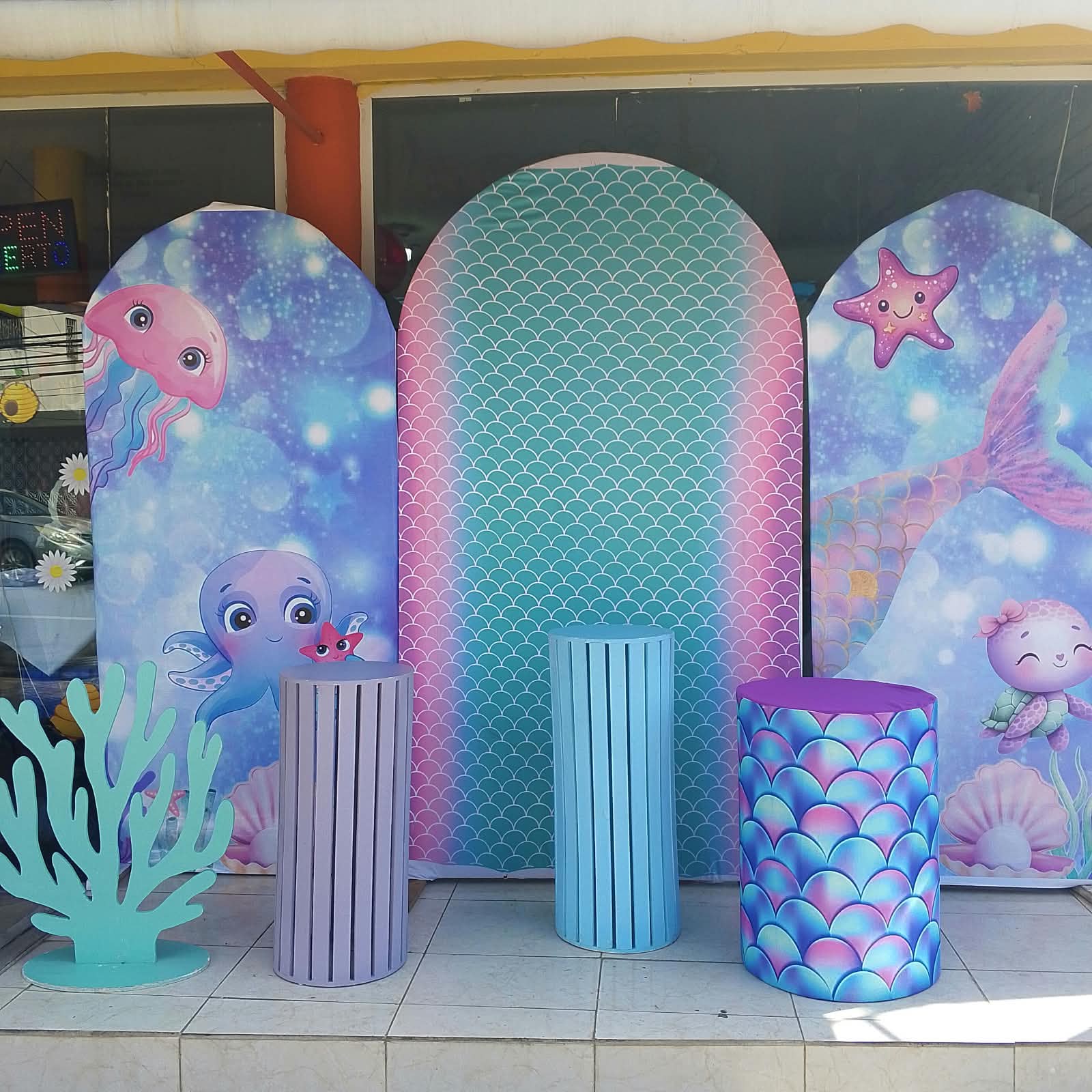 Set de sirena bajo el mar de Magasin Victoria con paneles arco, escamas turquesa y rosa, coral y cilindros pastel