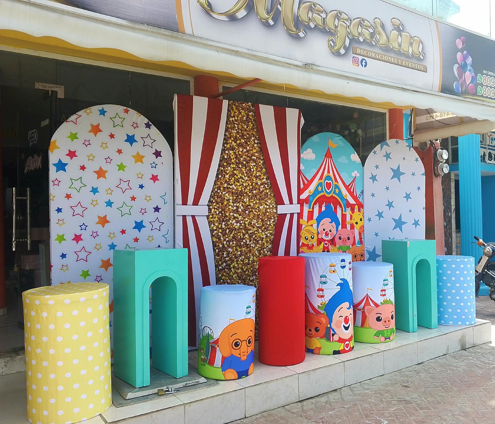 Set de circo de Plim Plim para cumpleaños en Higüey con cortinas rayadas, fondo dorado, estrellas y cilindros