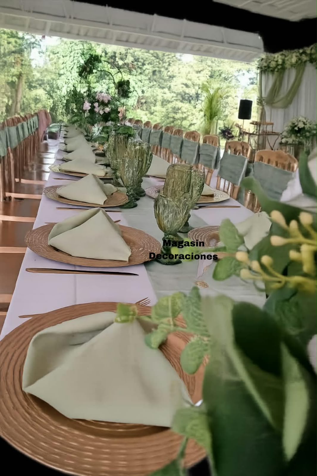 Mesa imperial con platos base dorados, servilletas verde salvia, copas verdes y centro de flores para evento especial