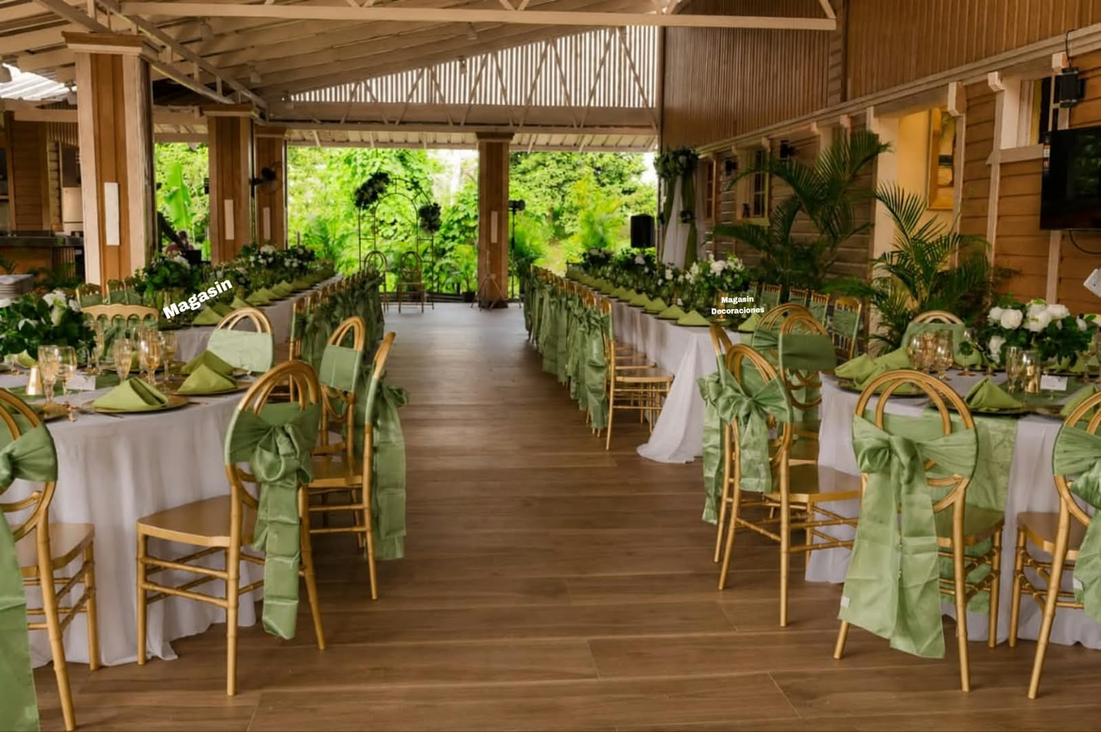 Mesa larga de boda montada por Magasin Victoria, sillas doradas con lazos verde sage, buffet al fondo