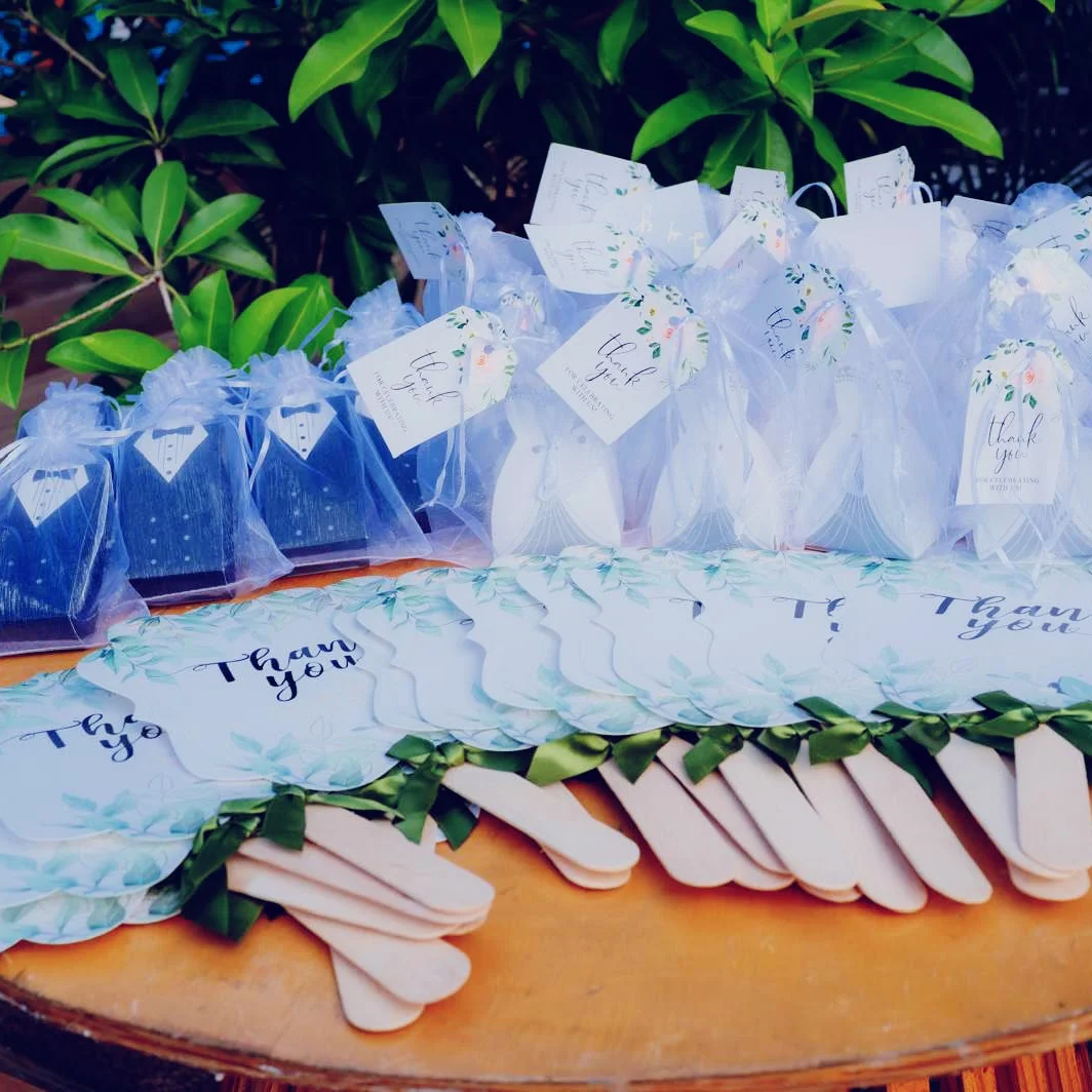 Recuerdos de boda (bolsas de organza y tags 'Thank you') sobre mesa de madera, montados por Magasin Victoria