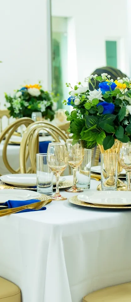 Mesa de boda con centro floral azul y blanco y copas doradas, montada por Magasin Victoria
